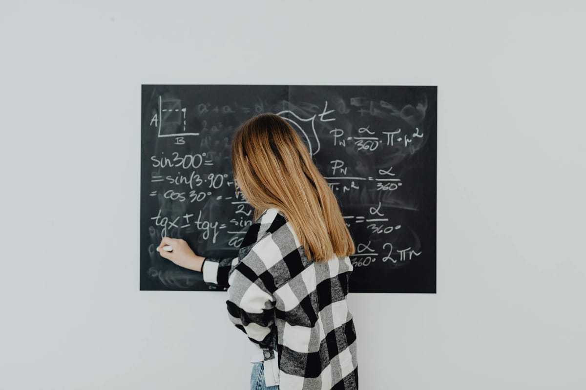 girl in plaid shirt solving a math problem
