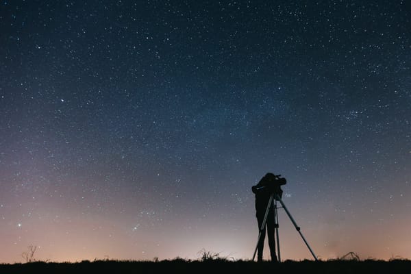 silhouette of person under starry sky