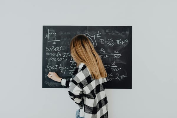 girl in plaid shirt solving a math problem