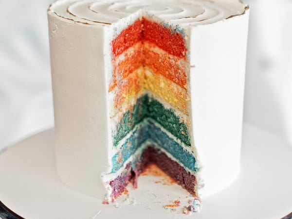 a tall cake with colorful layers